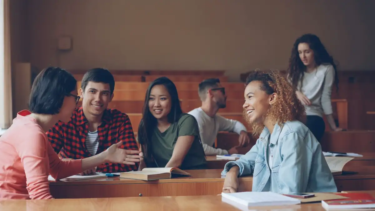 Studierende sitzen im Hörsaal und unterhalten sich