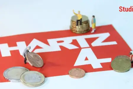 Schriftzug „Hartz 4“ mit Münzen und Miniaturfiguren als Symbolbild für Grundsicherungsgeld (früher Bürgergeld) im Studium