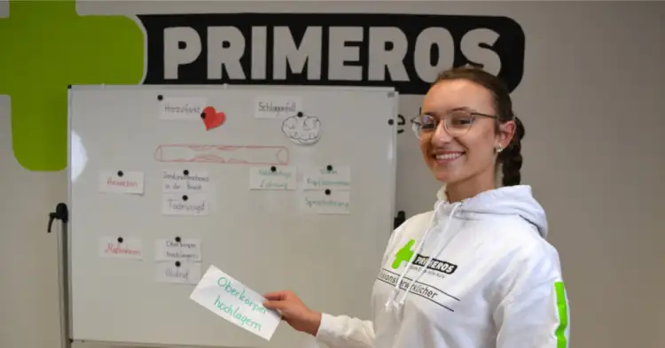 Primeros Erste-Hilfe-Kurs für Studenten – Ausbilder führt Teilnehmer durch Wiederbelebung