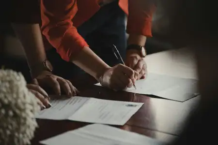 Erster Arbeitsvertrag wird am Tisch unterschrieben