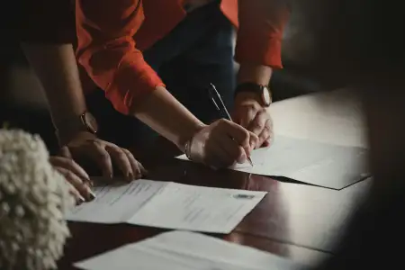 Erster Arbeitsvertrag wird am Tisch unterschrieben